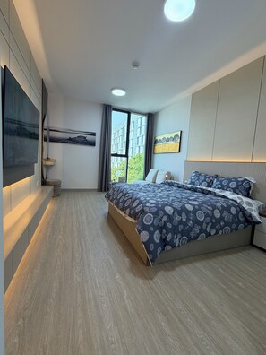 A modern bedroom with a large bed, built-in wardrobe, and a flat-screen TV mounted on the wall. - Cozy studio apartment with AC in charming Sharjah (Sharjah)