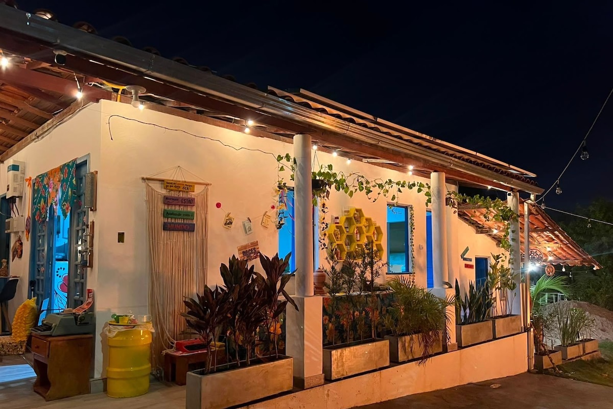 Um edifício com varanda coberta, plantas em vasos e luzes de fada.