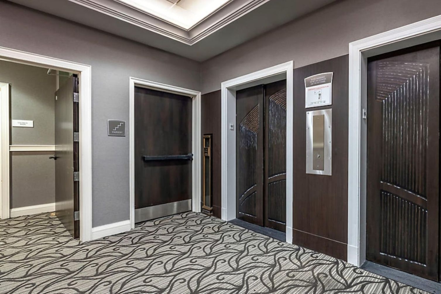 Un pasillo con tres puertas, cada una de un diseño diferente, que conducen a habitaciones u otras áreas.