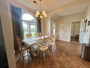 A dining area with a wooden table, chairs, and a chandelier.