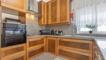 Una cocina con armarios de madera, un microondas, un tostador y un lavamanos.