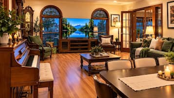 A spacious living room with a grand piano, comfortable seating, a large flat-screen TV, and a scenic view through arched windows.