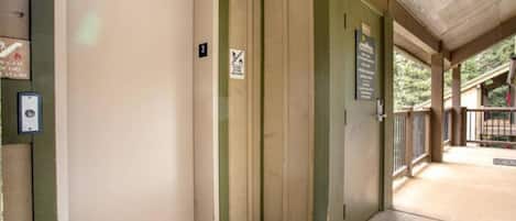 A hotel entrance with a closed door, a fire safety sign, and a wheelchair-accessible ramp.