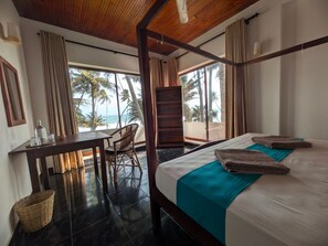 Ein Hotelzimmer mit Bett, Schreibtisch, Stuhl und Meerblick.