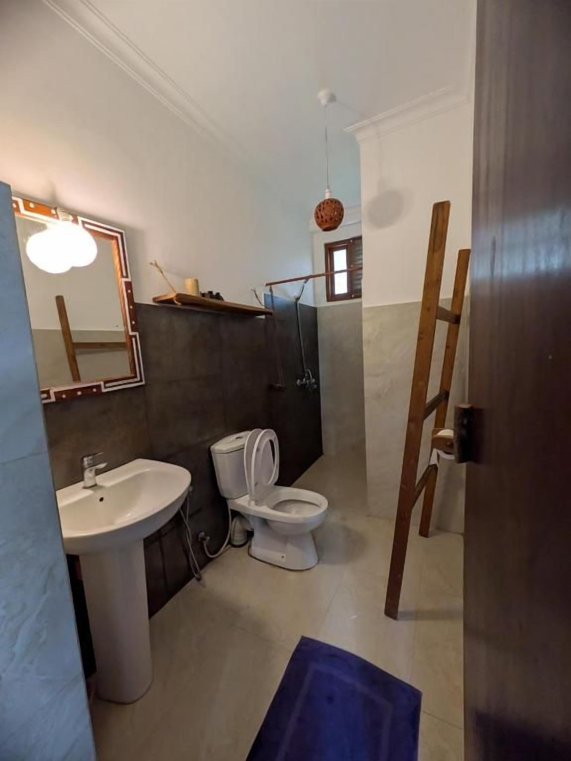A bathroom with a sink, toilet, and mirror.