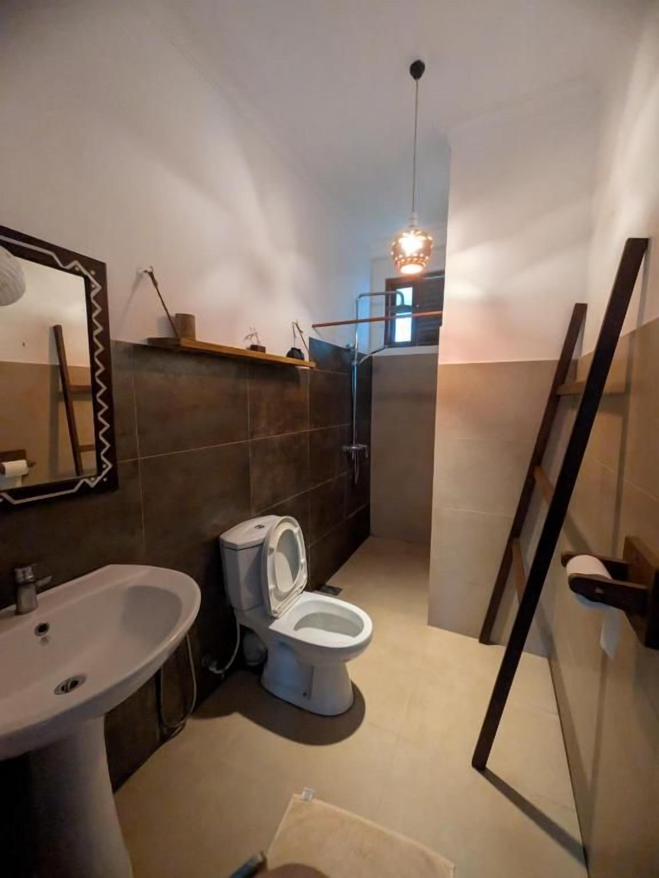 A bathroom with a sink, toilet, and shower area.