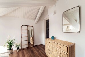 A room with a wooden dresser, a mirror, and two potted plants. - Como In The Sky - 150 steps, by MyHomeInComo (Como)