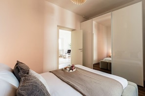 A modern bedroom with a bed, pillows, a bedside table, and a mirror. - Como In The Sky - 150 steps, by MyHomeInComo (Como)