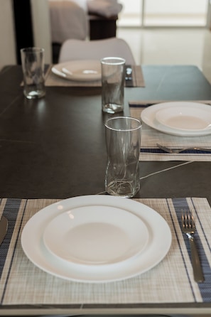 Una mesa dispuesta con un plato, un vaso y una servilleta sobre un mantel individual.