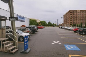 Un estacionamiento con carriles delimitados, una señal de dirección única y un anuncio de evento especial.