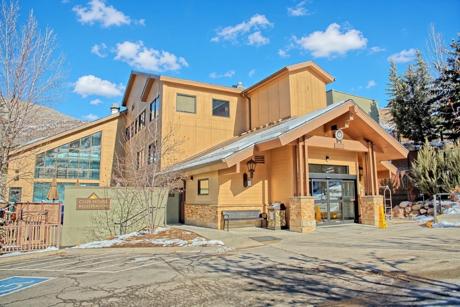A building with a registration sign, a covered entrance, and a parking lot.