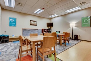 A conference room with a large table and chairs, a television, and a bookshelf. - Vail | Family Ski Escape | Pool + Hot Tub (Vail)