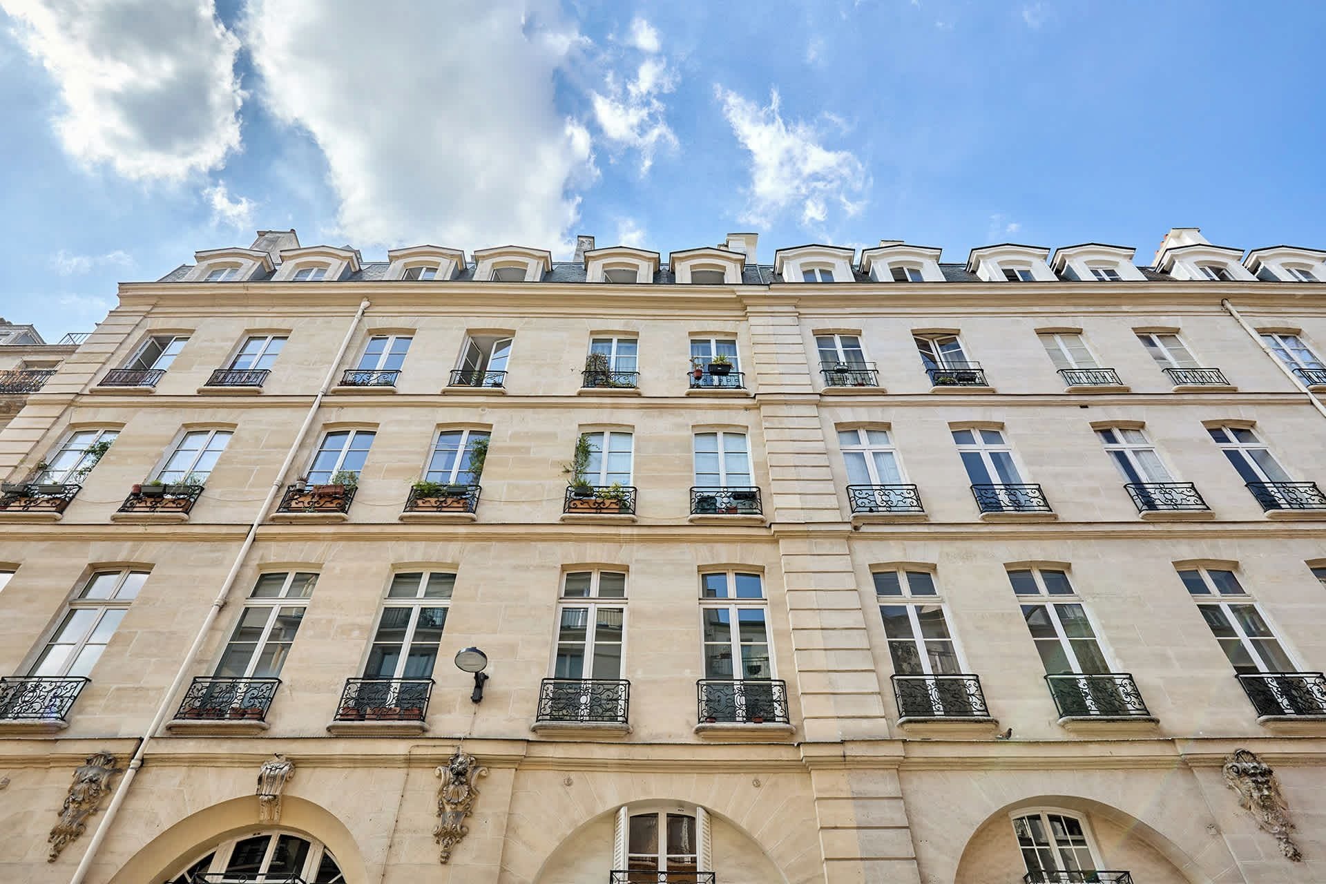 A multi-story building with a classical architectural style, featuring symmetrical windows and ornate balcony railings.