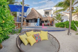 A beachside hotel with a thatched-roof structure, outdoor seating, and a pool area. - Villa Sunray. Entire 5 bedroom Villa with private pool and beach (Q.R.)