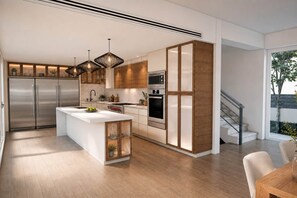 A modern kitchen with a central island, stainless steel appliances, and pendant lighting. - Miara Oasis - Celebrity Retreat in Casa de Campo (La Romana)