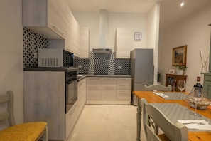 Une cuisine moderne avec un coin repas, équipée d’un four à micro-ondes, d’une cuisinière et d’un réfrigérateur.