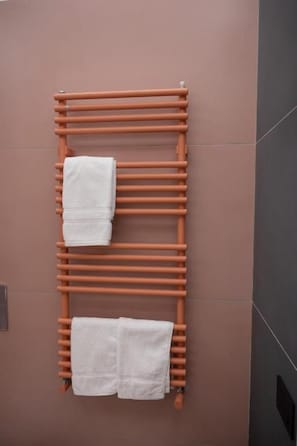 A towel rack with two towels against a wall. - Colour Suite (NAPOLI)