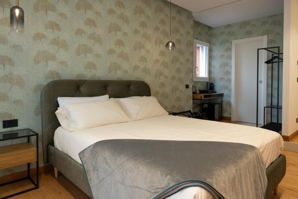 A bedroom with a large bed, a bedside table, a wardrobe, and a window.