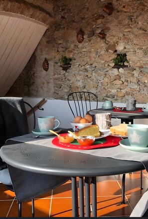 Ein Tisch mit einer Mahlzeit, ein Stuhl und eine Steinwand im Hintergrund.