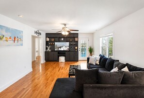 A modern living room with a black sofa, a coffee table, and a television on a black entertainment unit.