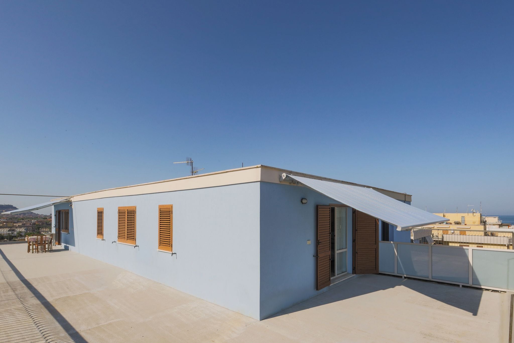 A modern building with a flat roof, large windows, and a door.