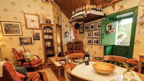 A cozy dining area with a wooden table, chairs, and a vase of flowers. - Teresa's Cottage (Bruckless)