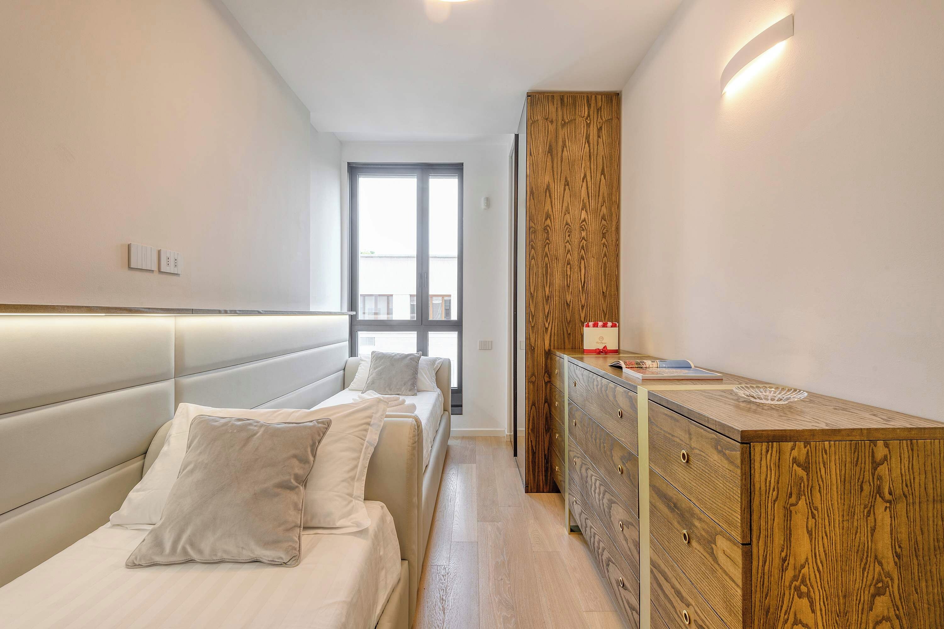 Una camera da letto moderna con un letto grande, comodini, un armadio e una finestra.