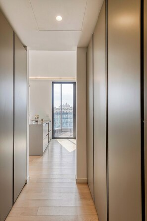 Un interno moderno con un corridoio che conduce a un balcone con vista sulla città.