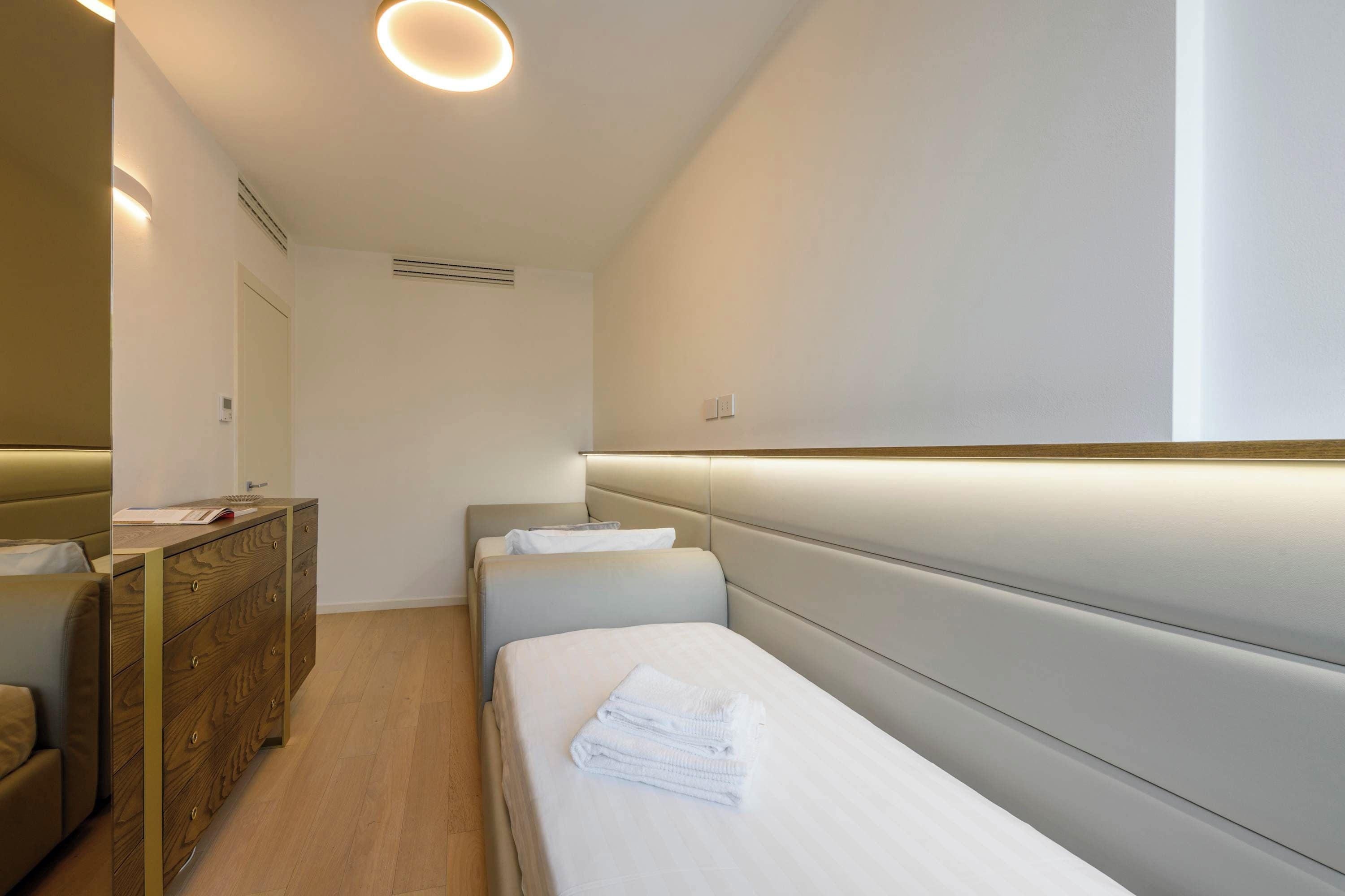 Une chambre d’hôtel avec un lit, une commode et un miroir.