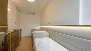 Una camera d'albergo con un letto, una cassettiera e uno specchio.