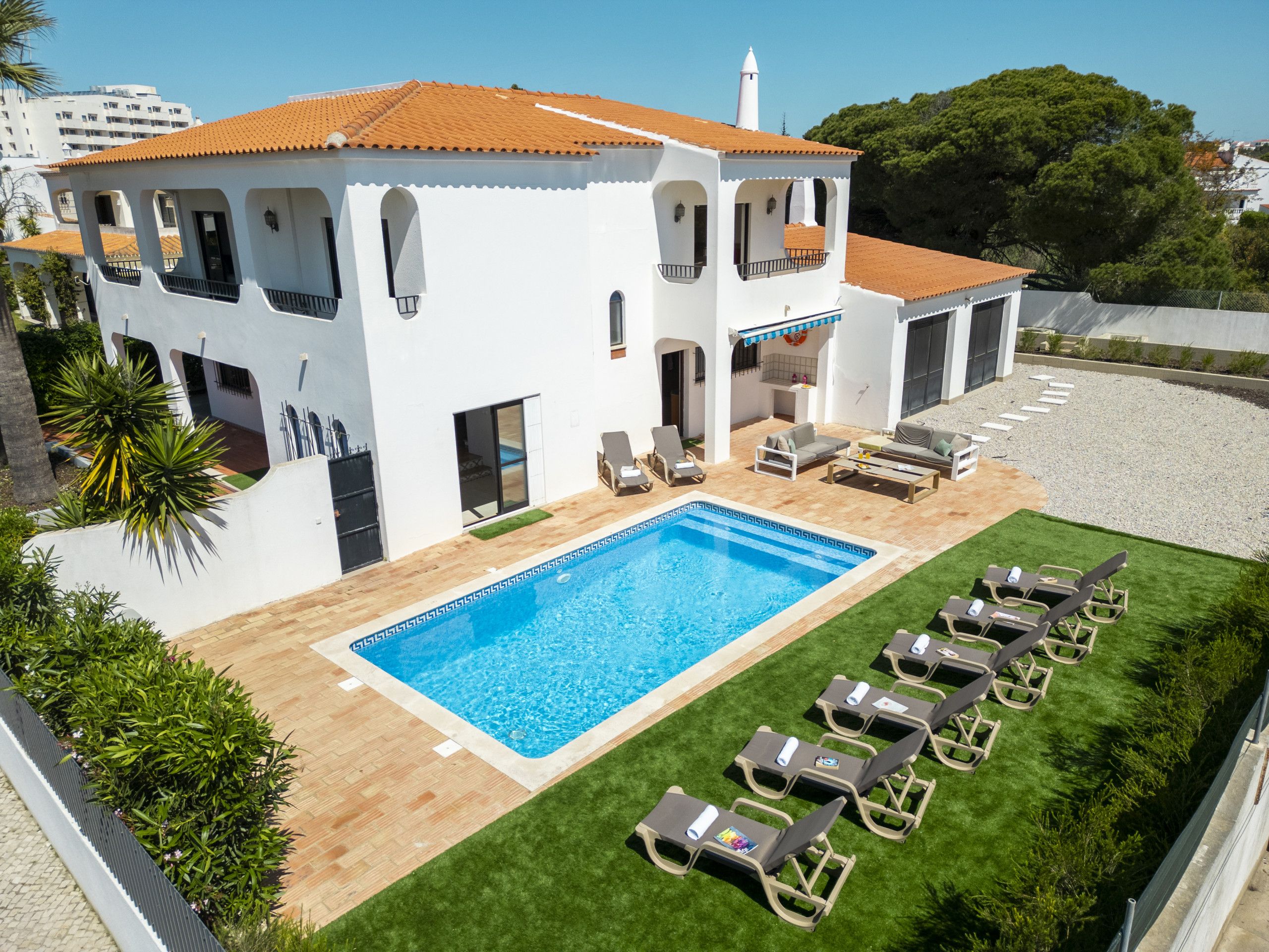 A two-story building with a swimming pool and outdoor seating.