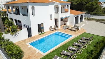 A two-story building with a swimming pool and outdoor seating.