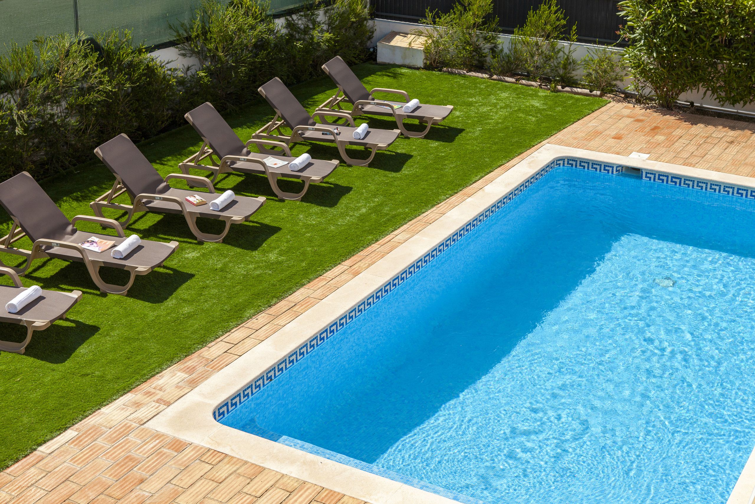 A rectangular swimming pool with a blue interior and a decorative border.