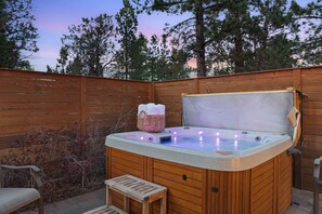 A hot tub with a wooden deck, a wicker basket with towels, and a bench. - Pine Lodge Chalet - Games Rm, Hot Tub, Dogs OK (Big Bear)