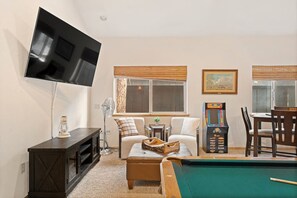 A living room with a pool table, a television mounted on the wall, and a gaming console. - Pine Lodge Chalet - Games Rm, Hot Tub, Dogs OK (Big Bear)