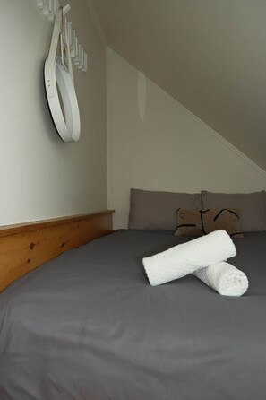 Ein Schlafzimmer mit einem Bett, Kissen und einem Handtuch.
