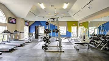 A gym with treadmills, weightlifting equipment, and exercise machines.