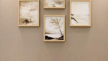 Eine Wand mit vier gerahmten Kunstwerken, die Naturdarstellungen zeigen.