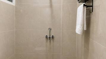 Een badkamer met douche, toilet en handdoekrek.