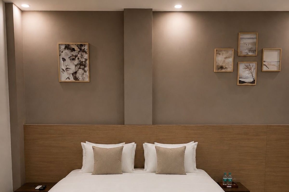 Un dormitorio moderno con una cama grande, cabecera de madera y mesitas de noche.