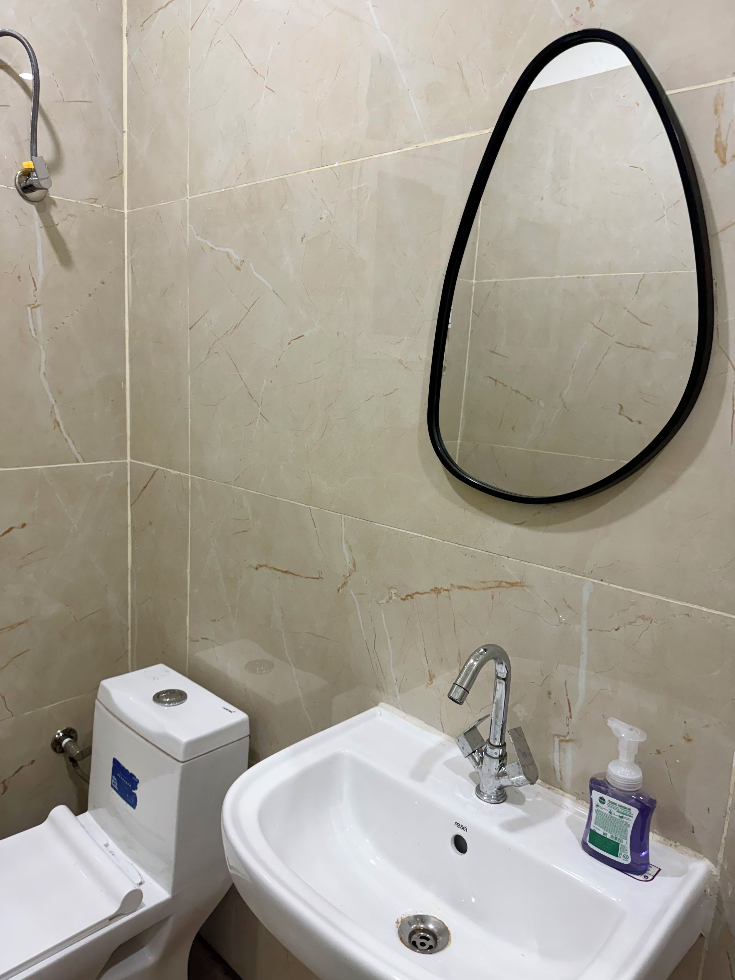 A bathroom with a white sink, a mirror, and a toilet.