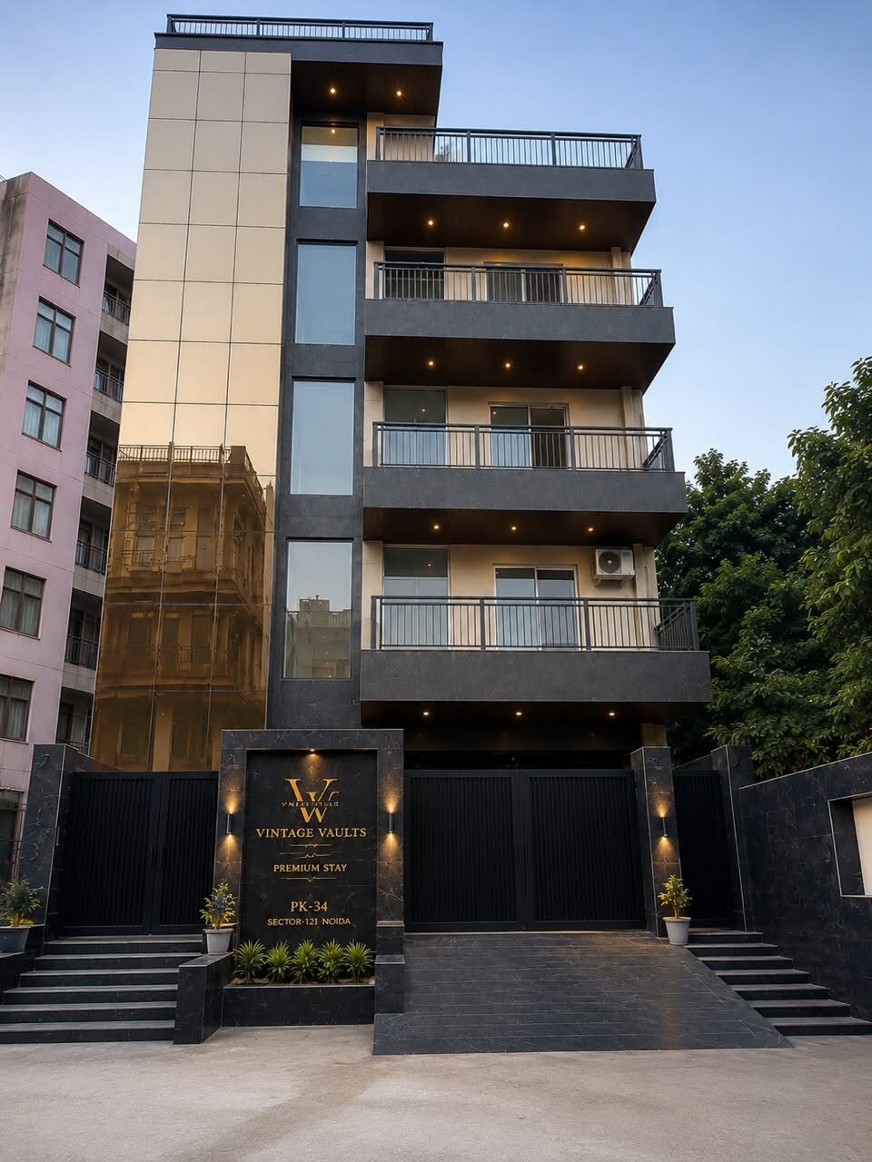 A multi-story building with a modern architectural design, featuring balconies, a gated entrance, and a sign indicating 'VINTAGE VAULTS PREMIUM STAY.'