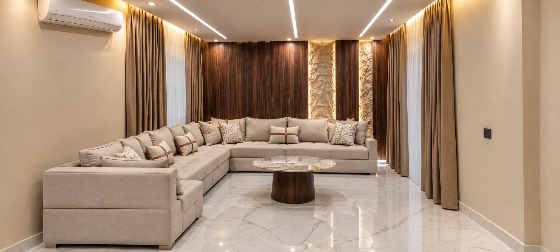 A modern living room with a sectional sofa, a round coffee table, and a wall-mounted air conditioning unit.