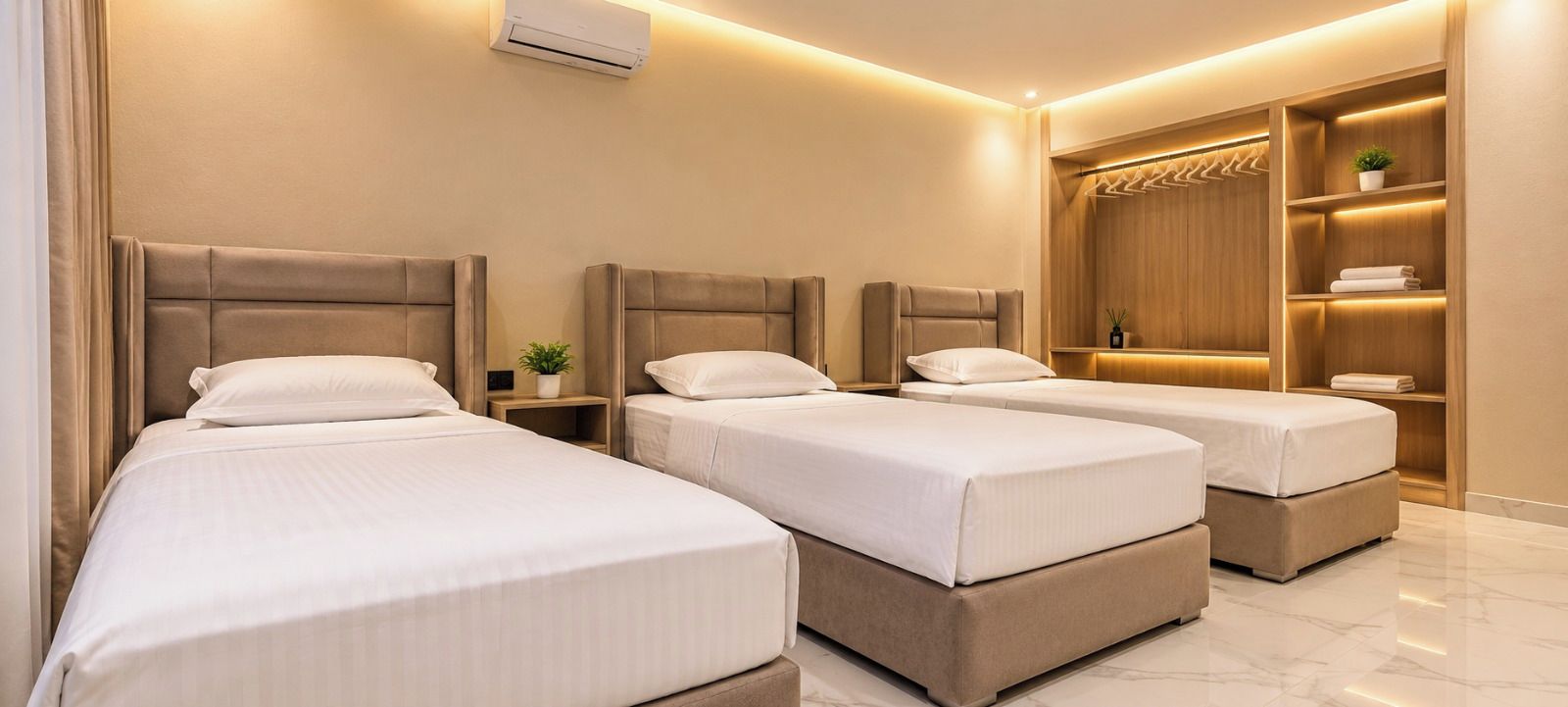 A hotel room with three beds, a wardrobe, and a small plant.