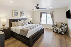 A bedroom with a bed, bedside tables, a chair, a ceiling fan, and a window with curtains. - Private Hot Tub, Fire Pit, BBQ, Pool - NEW Everything! (Washington)