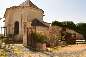 Ein Gebäude aus Stein mit Ziegeldach, einem verschlossenen Eingang und Topfpflanzen.