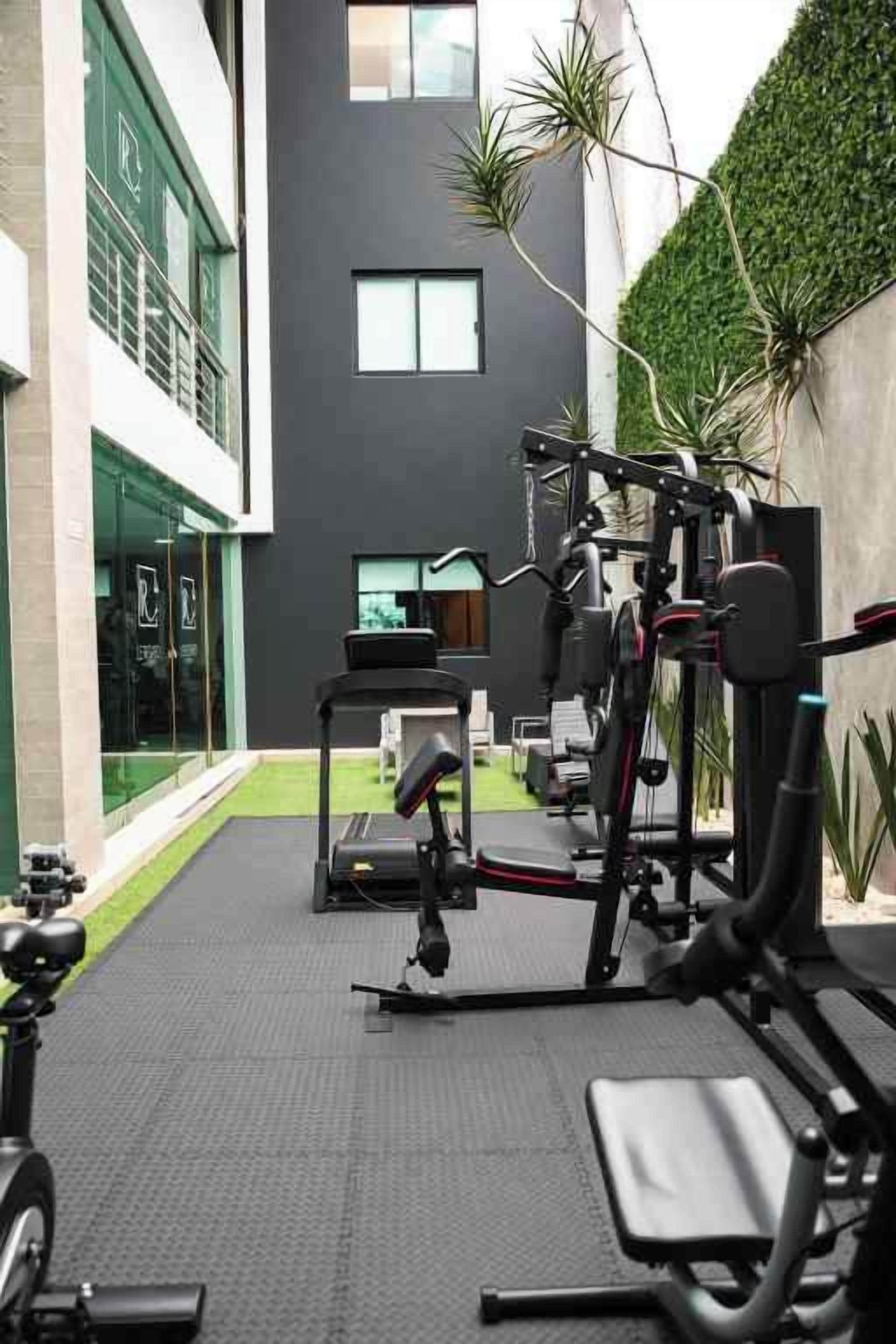 A gym with exercise equipment, a treadmill, and a weight bench.