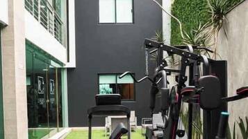 A gym with exercise equipment, a treadmill, and a weight bench.