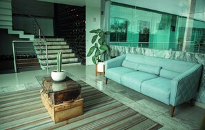 Ein modernes Wohnzimmer mit einem hellblauen Sofa, einem Couchtisch aus Holz mit einem Kaktus und einem Streifen Teppich.