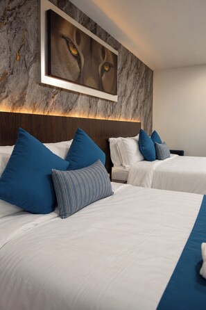 A hotel room with two beds, each with white bedding and blue pillows. - Le Regard (Zumpango)